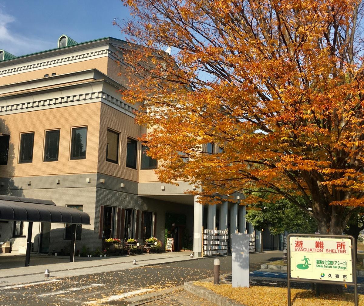 施設外観と避難所案内看板。