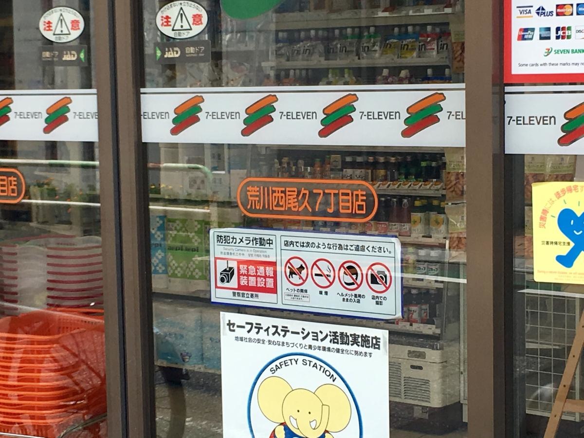 セブンイレブン荒川西尾久7丁目店のエントランスドアの店名表示