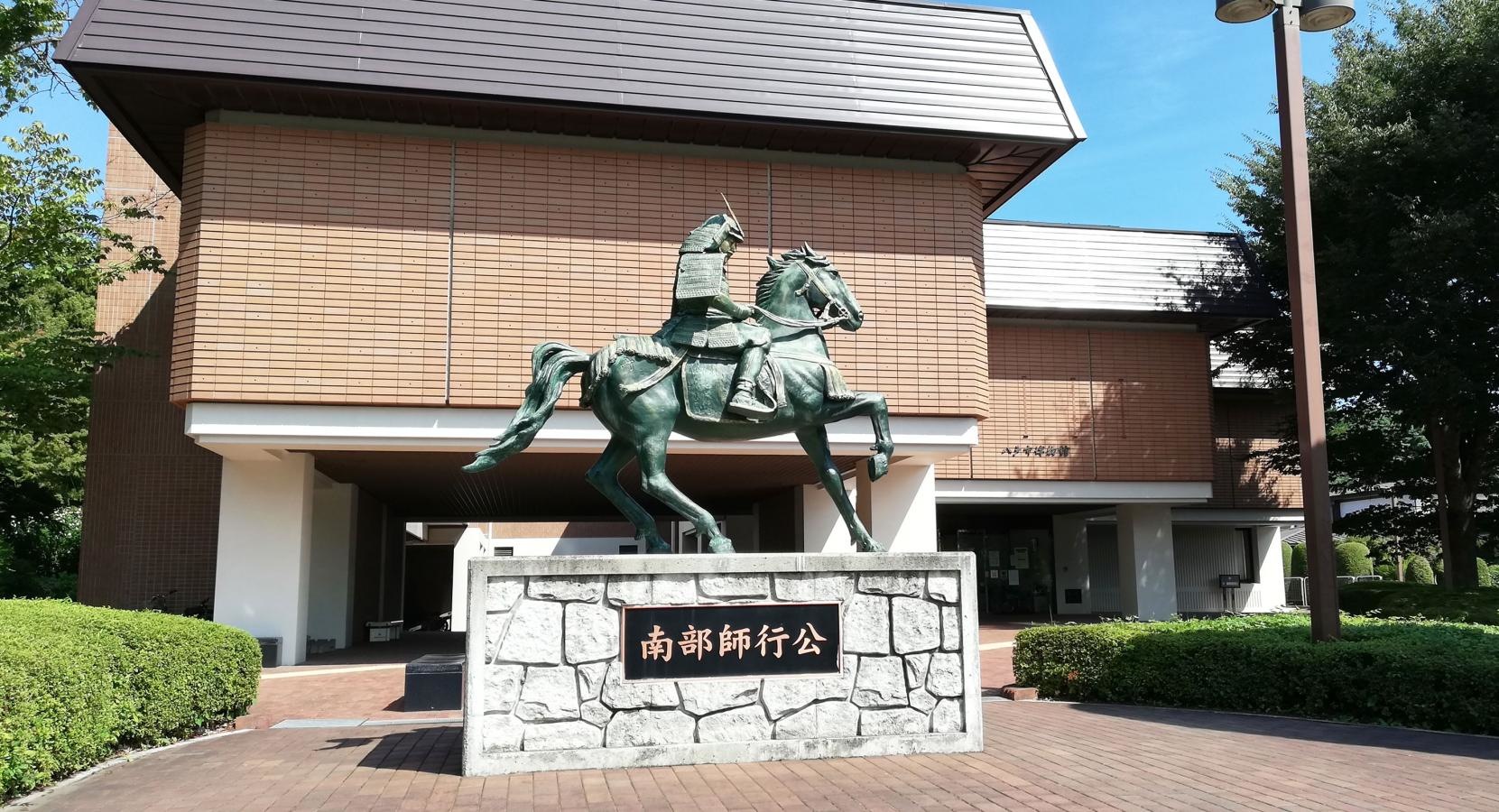 八戸市博物館と南部師行像
